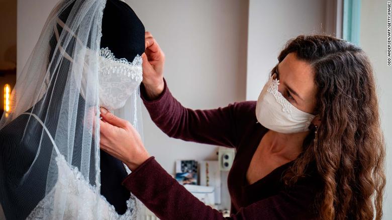 Photo 104 Designer Friedderike Jorzing adjusts a mannequin wearling a wedding dress with a face mask in her store in Berlin (March 30 Getty).jpg 