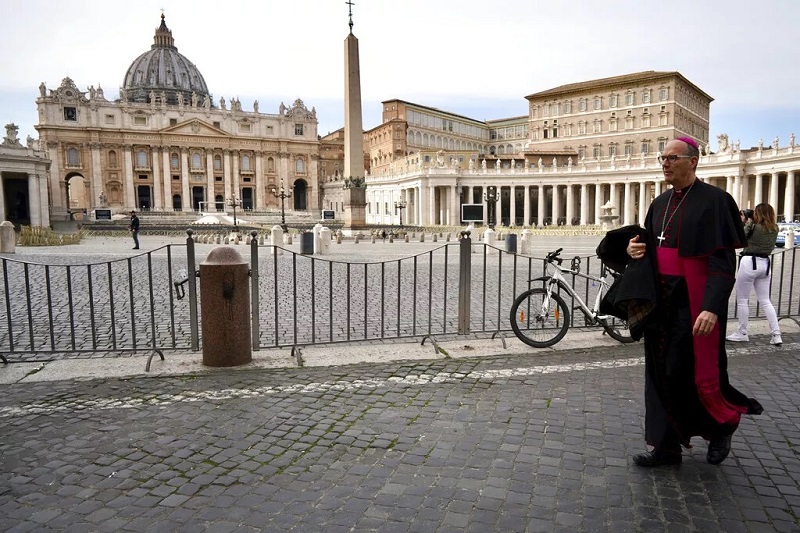 A prelate walks outside St. Peter's Square after the Vatican erected a new barricade at the edge of the square, in Rome (March 10 2020 - AP)