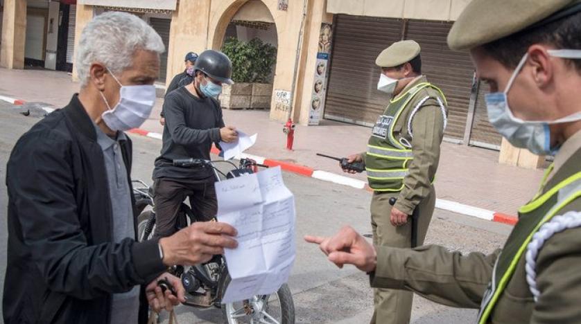 Moroccan police officers wearing protective masks check people at a roadblock during the coronavirus pandemic crisis. (AFP)