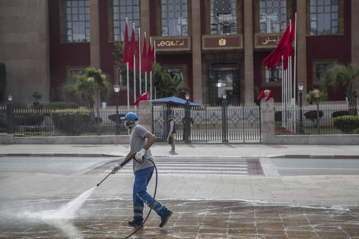 A worker disinfects a main avenue outside the parliament building in a bid to prevent the spread of coronavirus in Rabat (MAP)