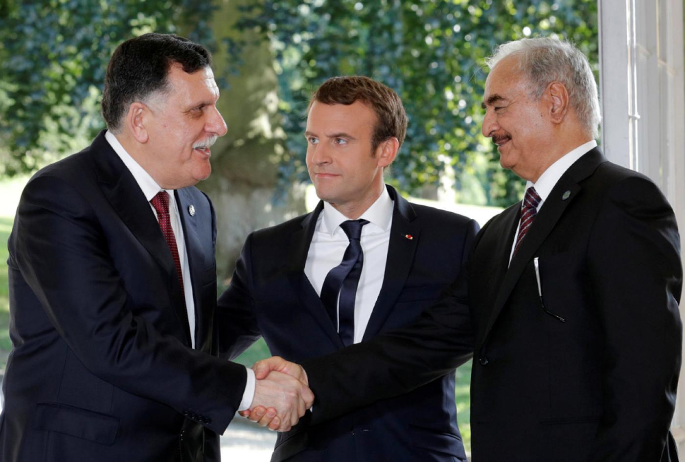President Macron stands between Fayez Sarraj and Khalifa Haftar [Reuters]