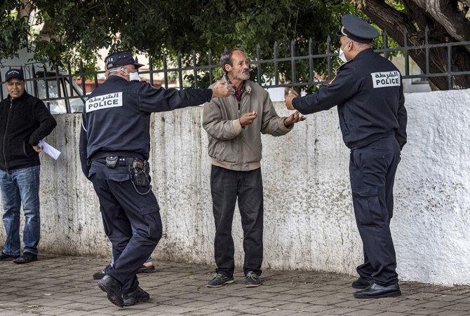 Policemen instruct a man to return home in Morocco’s capital Rabat on March 22 2020 (AFP)